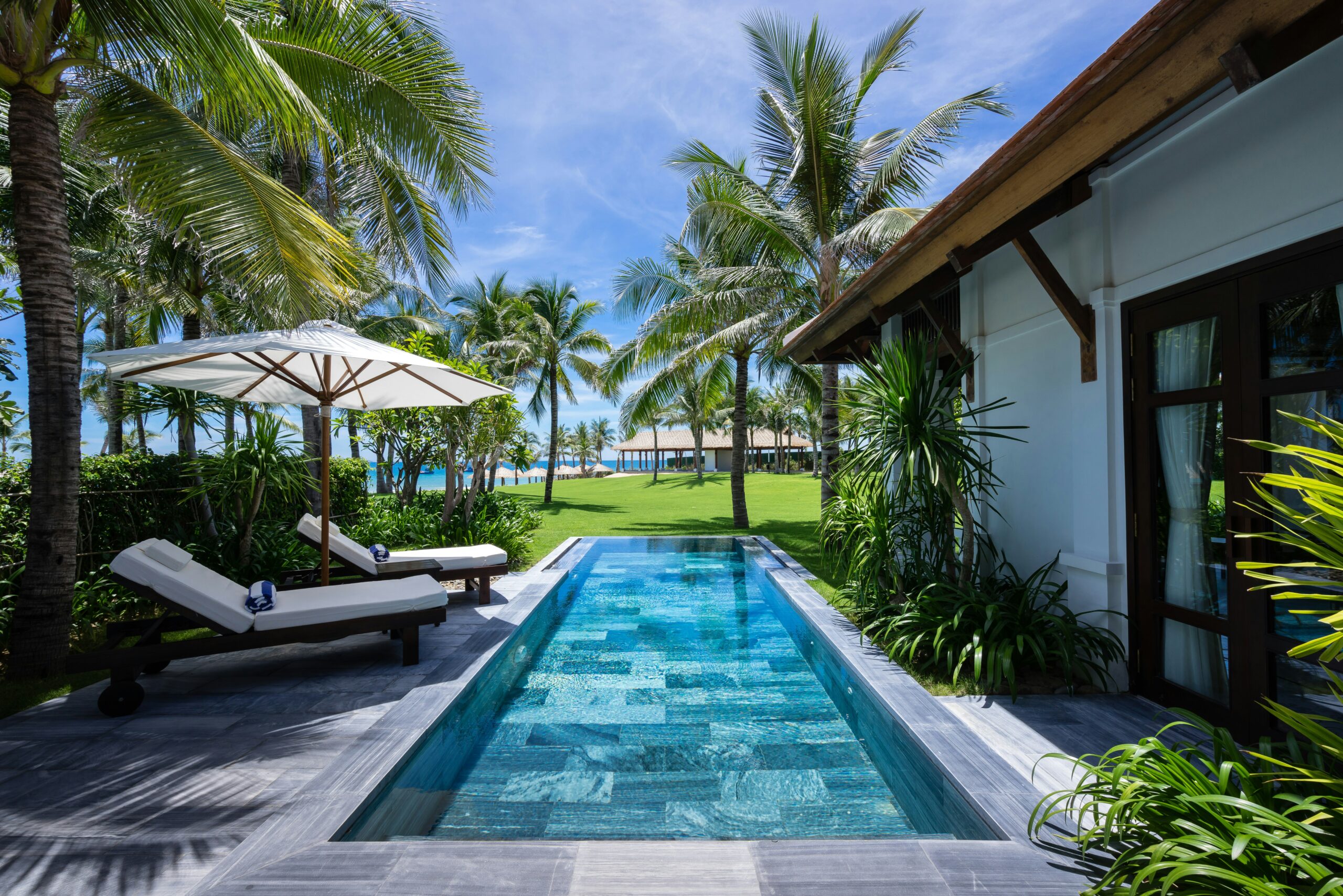 Villa with a private pool and sun loungers in a tropical garden